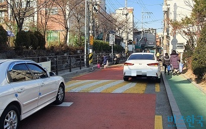 서울시 한 초등학교 어린이 보호구역. 뒤편에서는 차량이 진입 중인데도 두 어린이가 차도로 걷고 있다.  사진=박찬웅 기자