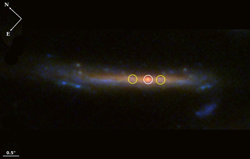 중력 렌즈 효과를 통해 포착된 먼 배경 은하 가운데 붉은 점이 보인다. 적색 거성으로 추정된다.