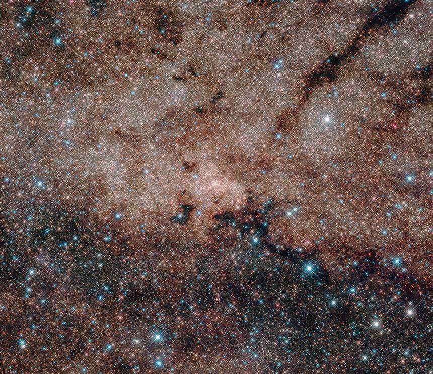 허블 우주망원경으로 관측한 우리 은하 중심의 핵 성단을 이루는 별들. 사진 속 푸르게 빛나는 밝은 별들은 훨씬 가까이 있는 배경 별들이다. 그 너머 더 먼 배경에서 빛나는 미지근한 별들 대부분이 전부 우리 은하 중심 핵 성단을 이루는 별들이다. 우리 은하 중심부는 지구로부터 약 2만 7000광년 떨어져 있다. 사진=NASA, ESA, and the Hubble Heritage Team(STScI/AURA); Acknowledgment: T. Do and A. Ghez(UCLA), and V. Bajaj(STScI)
